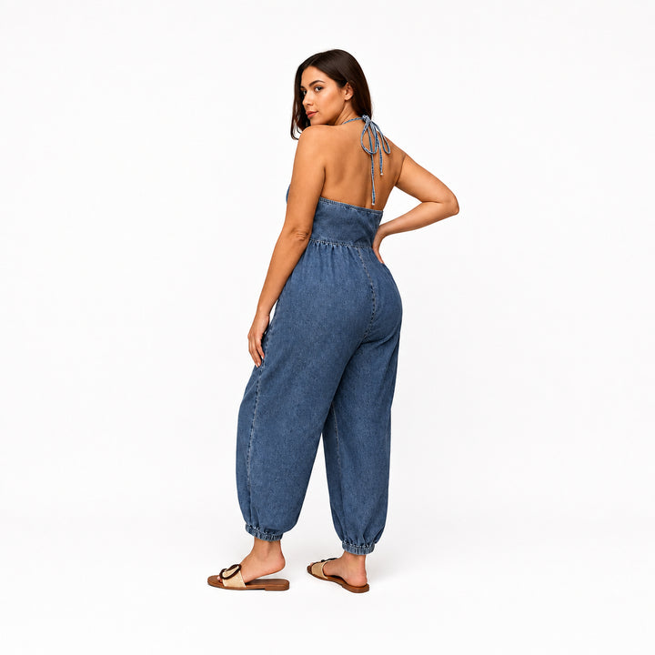 Dark blue plus-size halter denim utility jumpsuit on model, back view