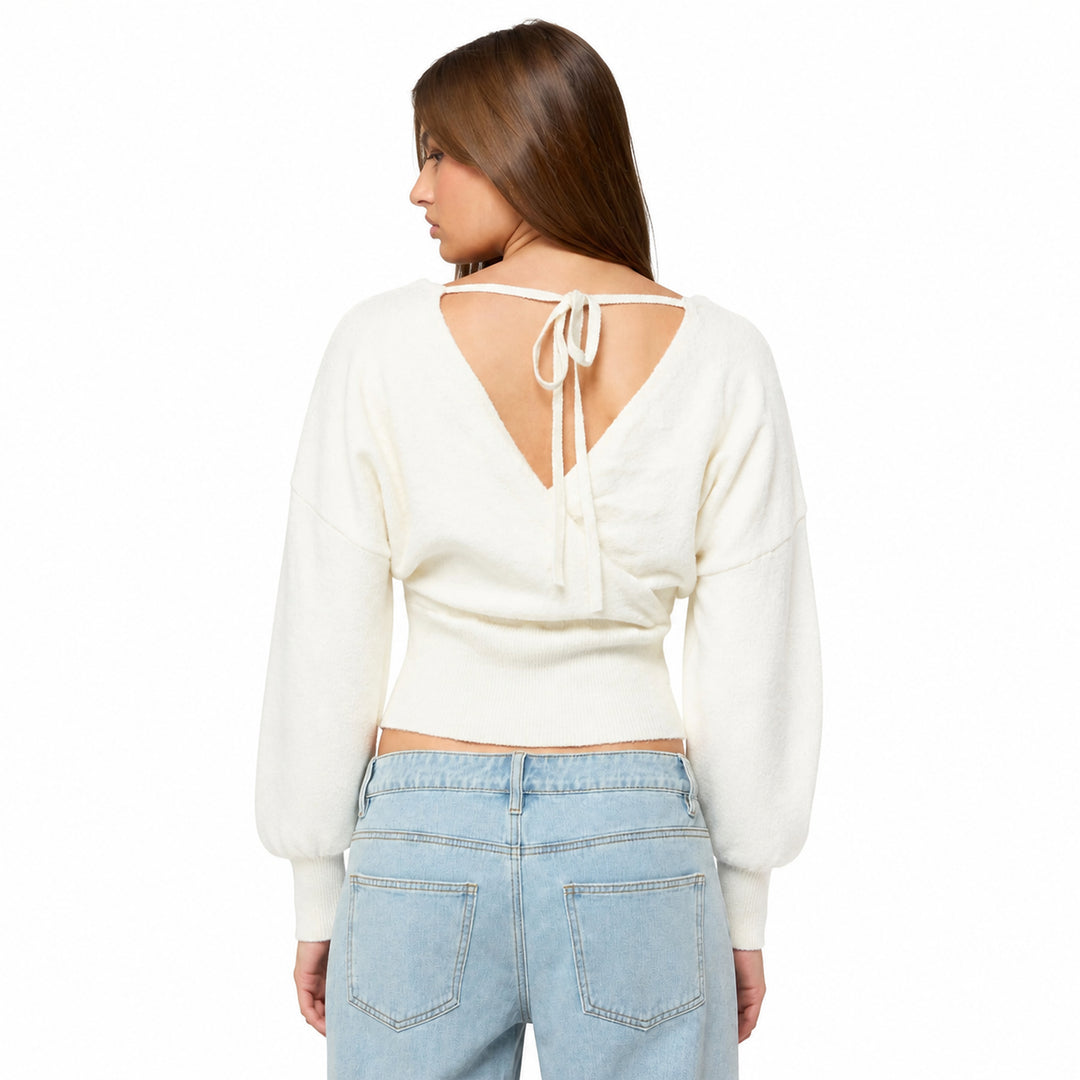White cross-front knit sweater with open tie back on model, back view