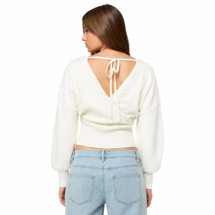White cross-front knit sweater with open tie back on model, back view