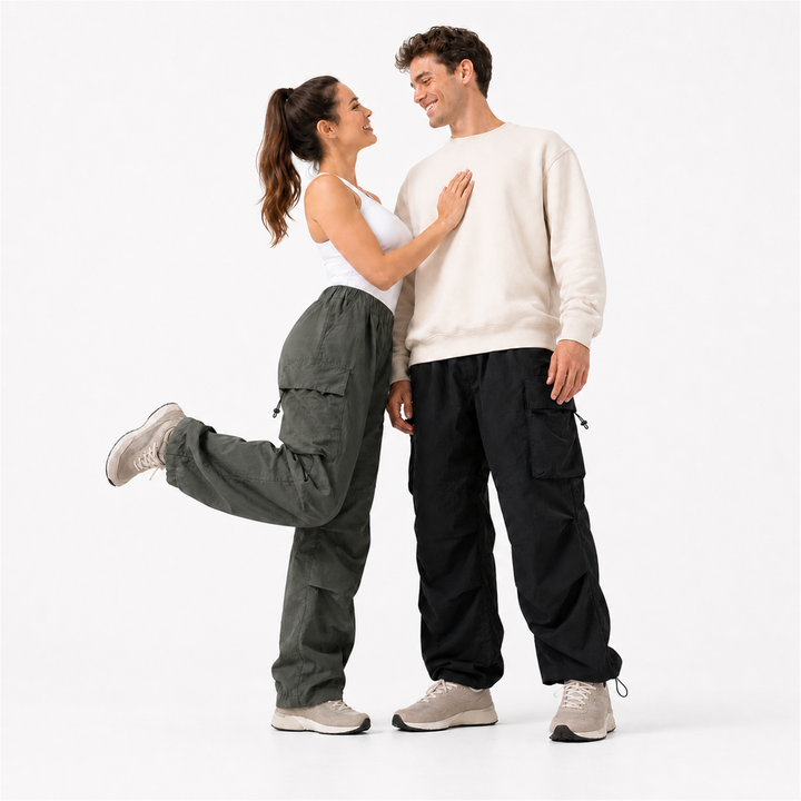 American couple wearing gray-green and black water-resistant cargo pants, full-body low-angle studio view