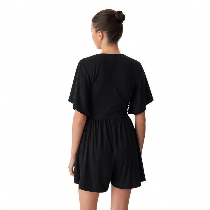Back view of The Elara Black dress-style romper showing the one-piece shorts construction