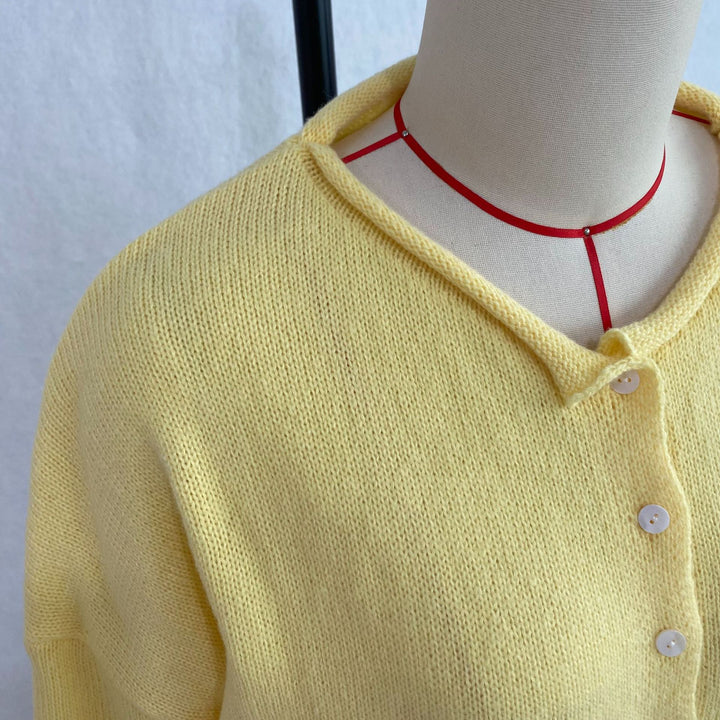 Close view of the Yellow cardigan collar, knit texture, and buttons