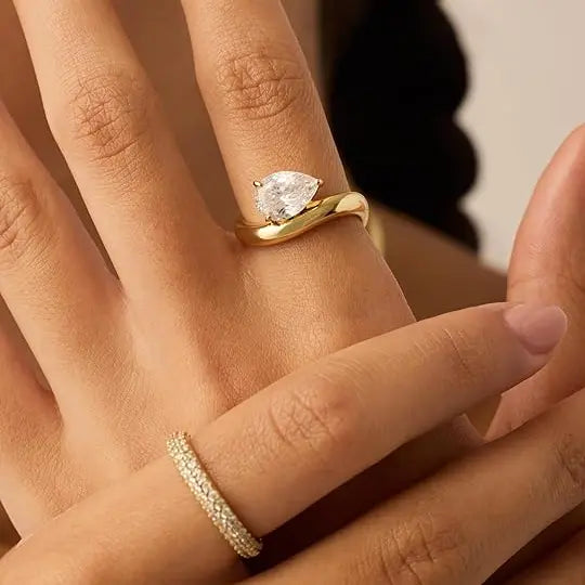 Gold-tone pear-cut ring worn on hand