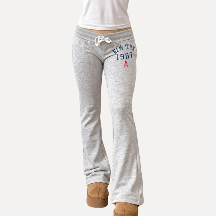 The Elara Low-Rise Graphic Drawstring Flare Pants in Grey, front view