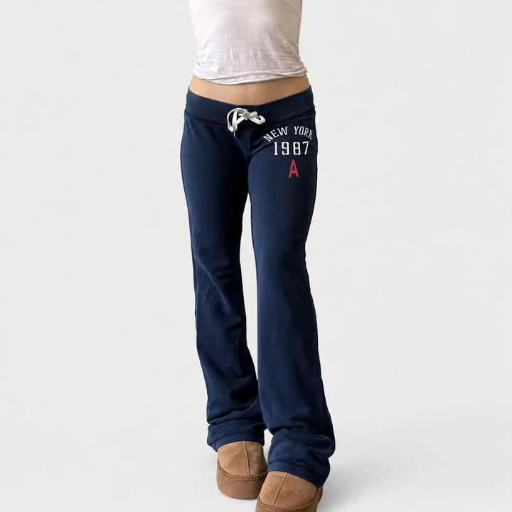 The Elara Low-Rise Graphic Drawstring Flare Pants in Navy, front view