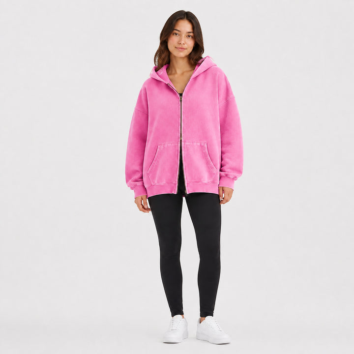 Pink oversized double-zip hoodie on female model, studio front view