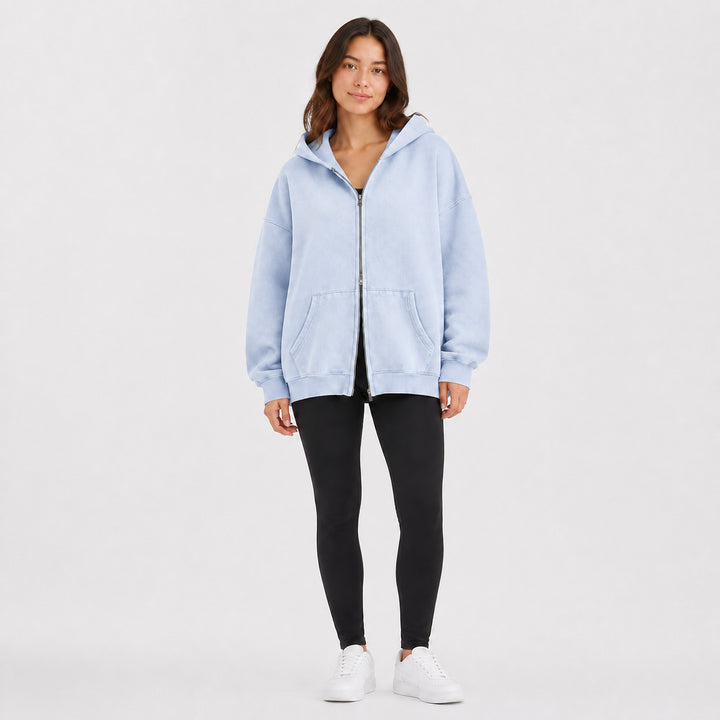 Light blue oversized double-zip hoodie on female model, studio front view